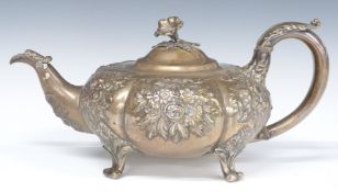 Victorian hallmarked silver squat teapot raised on four feet with repoussé decoration and flower