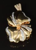 An 18ct gold pendant in the form of a stylised flower set with diamonds, 6.4g