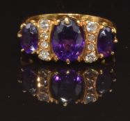 An 18ct gold ring set with three oval cut amethysts and diamonds, size L, 4.4g