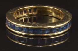 An 18ct gold eternity ring set with square cut sapphires, size N, 5.4g