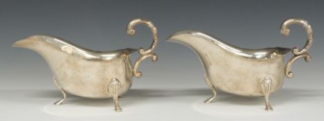 Pair of modern hallmarked silver gravy boats, raised on three feet, Birmingham 1975, maker