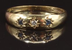 A 9ct gold ring set with a diamond and two sapphires in star settings, size P, 1.7g