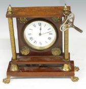 French brass mantel clock mounted on mahogany frame with brass pillar supports, raised on paw