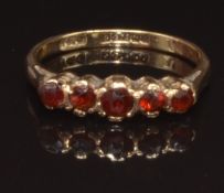 A 9ct gold ring set with garnets, size K, 1.7g