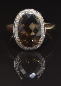 A 9ct gold ring set with smoky quartz surrounded by diamonds, size U, 4.3g