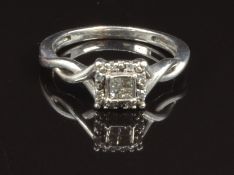 A white metal ring set with four square cut diamonds surrounded by round cut diamonds, size J, 2.1g