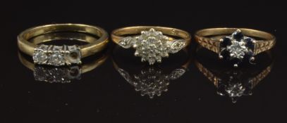 Three 9ct gold rings including one set with a diamond and sapphires, another set with a cluster of