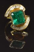 An 18ct gold ring set with a natural Colombian apple green emerald of approximately 5ct and 34