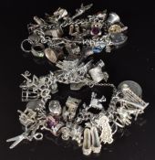 Two silver charm bracelets with over 40 silver charms including rabbit, train, caravan, boat, hat,
