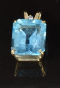 A 9ct gold pendant set with an emerald cut blue topaz and a diamond, 2g