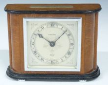 Elliot mantel clock with Kendal & Dent to silvered engraved Roman dial, the wooden case with