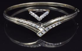 A 9ct gold bangle set with diamonds in a V shape and a similar ring, 9.4g