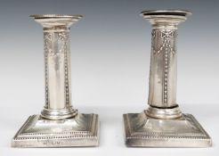 Victorian pair of hallmarked silver candlesticks with embossed swag decoration, London 1895 and