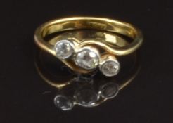 An 18ct gold ring set with three diamonds in a twist setting, size J, 2.4g