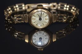 Unnamed 9ct gold ladies wristwatch with blued hands, gold Arabic numerals and hour markers, silver