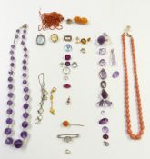 A collection of gemstones including amethyst, garnet, citrine, coral necklace, saphirite,
