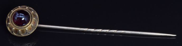 Victorian 15ct gold stick pin set with a garnet cabochon, 8.4cm long