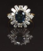 An 18ct gold ring set with an oval cut sapphire surrounded by baguette and round cut diamonds,