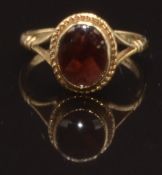 A 9ct gold ring set with an oval garnet, size O, 2.9g
