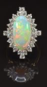 An 18ct gold ring set with a large oval opal cabochon of approximately 4ct surrounded by 24 round