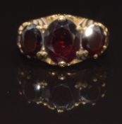 A 9ct gold ring set with three oval cut garnets, size L, 4g