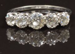An 18ct white gold ring set with five old cut diamonds, the centre stone approximately 0.5ct, in