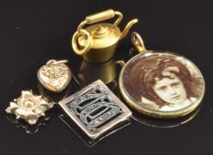 A 9ct gold locket, yellow metal kettle charm, 9ct gold heart charm, 2.1g, and a 9ct gold and
