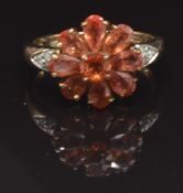 A 9ct gold ring set with garnets and diamonds in a flower cluster, size M, 3.5g