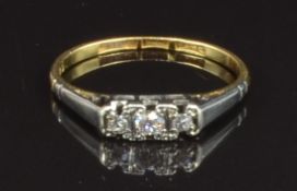 An 18ct gold ring set with three round cut diamonds in a platinum setting, size O, 2g
