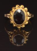 A 9ct gold ring set with an oval garnet within a twisted border, size I, 2.6g