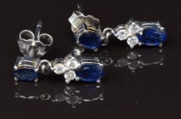 A pair of 18ct white gold earrings set with two oval cut sapphires and three diamonds to each, 3g
