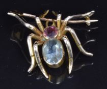 A c1900 gold brooch in the form of a spider set with an oval aquamarine and a round cut topaz, 2 x