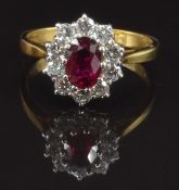 An 18ct gold ring set with an oval cut ruby of approximately 0.9ct surrounded by ten round cut