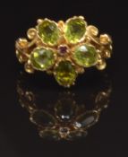 A 9ct gold ring set with a ruby surrounded by peridot in a flower cluster, size N, 4.1g