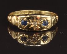 An 18ct gold ring set with a diamond and two sapphires in star setting, Birmingham 1916, size M, 1.