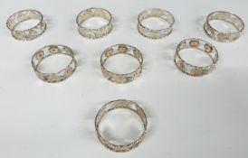 Set of eight Eastern white metal napkin rings, four decorated with animals and four with flowers,
