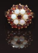 A 9ct gold ring set with garnets and opals in a cluster, size M, 4.8g