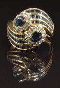 An 18ct gold ring set with oval and baguette cut sapphires and round cut diamonds, size N, 7.3g