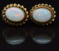 A pair of 9ct gold earrings set with an opal to each, 1.5g