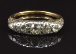 Victorian 18ct gold ring set with five old cut diamonds in a scrolling setting, the centre diamond