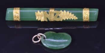A 9ct gold and jade brooch with NZ for New Zealand and a jadeite kidney bean charm/ pendant