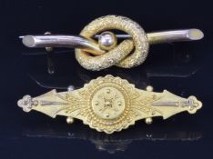 A 9ct gold love knot brooch (2.2g) and a Victorian Etruscan Revival 15ct gold brooch with glass