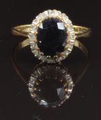 A 9ct gold ring set with an oval cut sapphire surrounded by diamonds, size M, 2.5g