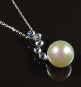 An 18ct white gold pendant set with a faux pearl and sapphires on an 18ct white gold chain, 5.2g,