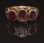 An early Victorian rose gold ring set with three oval cut foiled garnets, size N, 2.3g