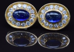 A pair of 18ct gold earrings set with Sri Lankan sapphire cabochons of approximately 5ct, surrounded