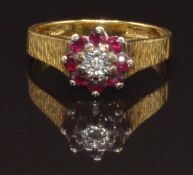 An 18ct gold ring set with a diamond surrounded by rubies, size M, 3.9g