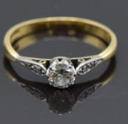 An 18ct gold ring set with a 0.25ct diamond with diamond encrusted shoulders, size M, 1.8g