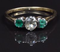 An 18ct gold ring set with an old cut diamond of approximately 0.26ct and emeralds, size M, in