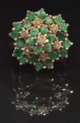 A 9ct gold ring set with round cut emeralds and diamonds in a large cluster, size O, 4.7g